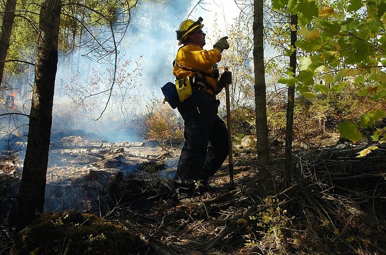 Seeley Lake Firefighter Mike Greer points out where flame is taking hold on the south side of the fire.