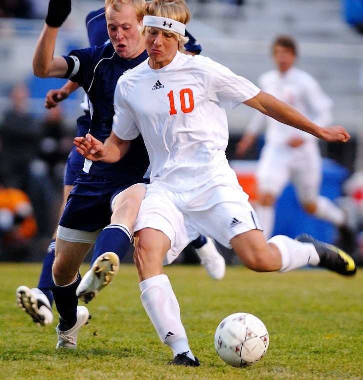 Flathead's Irie Anderson winds up for a shot towards the net as Glacier's Seth Bumgarner sticks out his leg in hopes of deflecting the shot during Thursday evening's game at Legends Stadium.