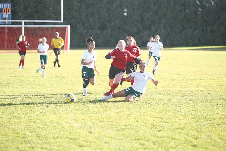 Junior Danya Mercado (16) slide tackles the ball away from Omak freshman forward Jenna Bucsko.