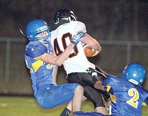 <p>Erik Lauer, left, and Logan Nelson go high and low tackling Frenchtown's Cole Allen in fourth quarter.</p>