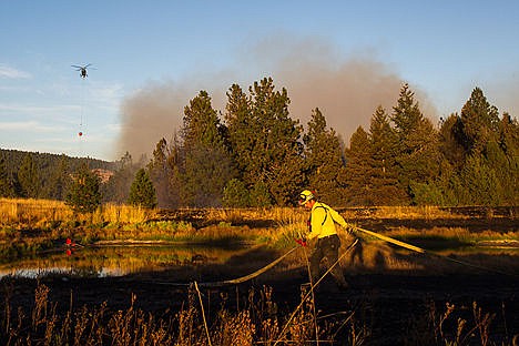 &lt;p&gt;Worley Firefighter Dan Mooney pulls up a firehose as his engine moves locations to fight a wildfire that started Tuesday afternoon. Worley Fire, Idaho Department of Lands, Mica-Kidd Isladn Fire, Spokane County and the Forest Service all responded to fight the wildfire.&lt;/p&gt;