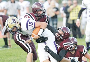 <p>Michael Miller, center, and Gage Tallmadge go high and low to tackle Cut Bank's Jess Ray Sept. 20.</p>