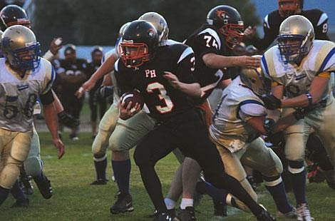 Jennifer McBride/Valley Press Junior Dillon Fryxell runs through a horde of Thompson Falls players who eventually bring him down.