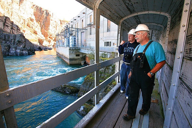 Kerr Dam opeator Rich Bonnes and Leader sports editor Brandon Hansen walk along the base of Kerr Dam.