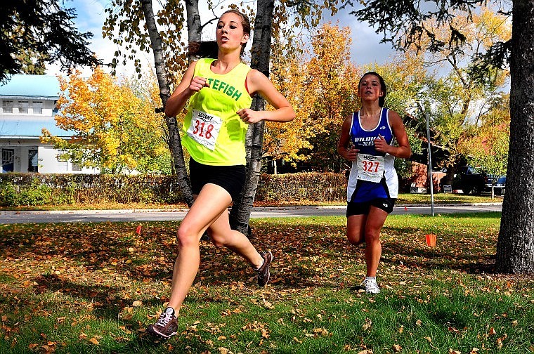 Whitefish's Bailey Eaton keeps a step ahead of Columbia Falls' Jinise Osborne during Saturday's Whitefish Invitational. Osborne edged Eaton at the finish line to place second.