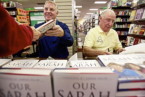 &lt;p&gt;Chuck Heath, Jr., left, and his father Chuck Heath, Sr. sign copies of their book &quot;Our Sarah &#151; Made in Alaska&quot; during an event Monday at Hastings in Coeur d'Alene.&lt;/p&gt;