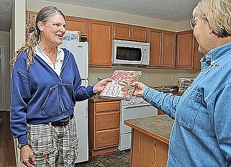 &lt;p&gt;Habitat for Humanity of North Idaho's Marianne Bethke, right, gives Kathy French a cookbook in the kitchen of French's new home Saturday during the dedication celebrating the nonprofit's 34th completed home.&lt;/p&gt;