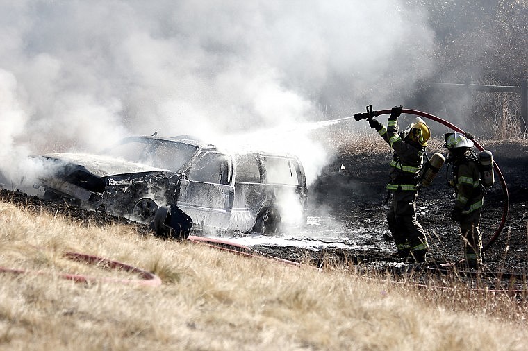 <p>Superior Volunteer Firefighters work to douse an engulfred car with a mixture of foam and water Sunday.</p>