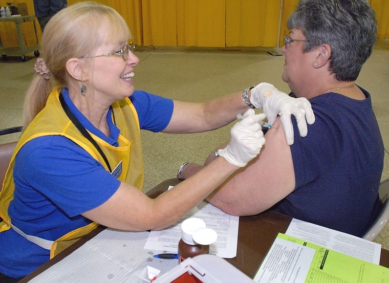 Terri Fehlhaber, Flathead City-County Health Department immunization nurse, administers a seasonal flu shot Wednesday to Kalispell resident Jan Bailey during the health department&#146;s seventh annual flu shot clinic at the Flathead County Fairgrounds.