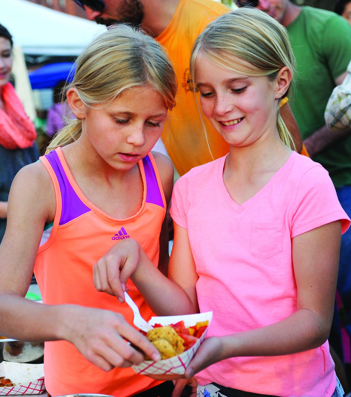 <p>Tommye Kelly, left, tastes Kenal Reed's salsa she made at the Harvest Celebration before "Where the Wild Things Are," on Tuesday. (Aaric Bryan/Daily Inter Lake)</p>