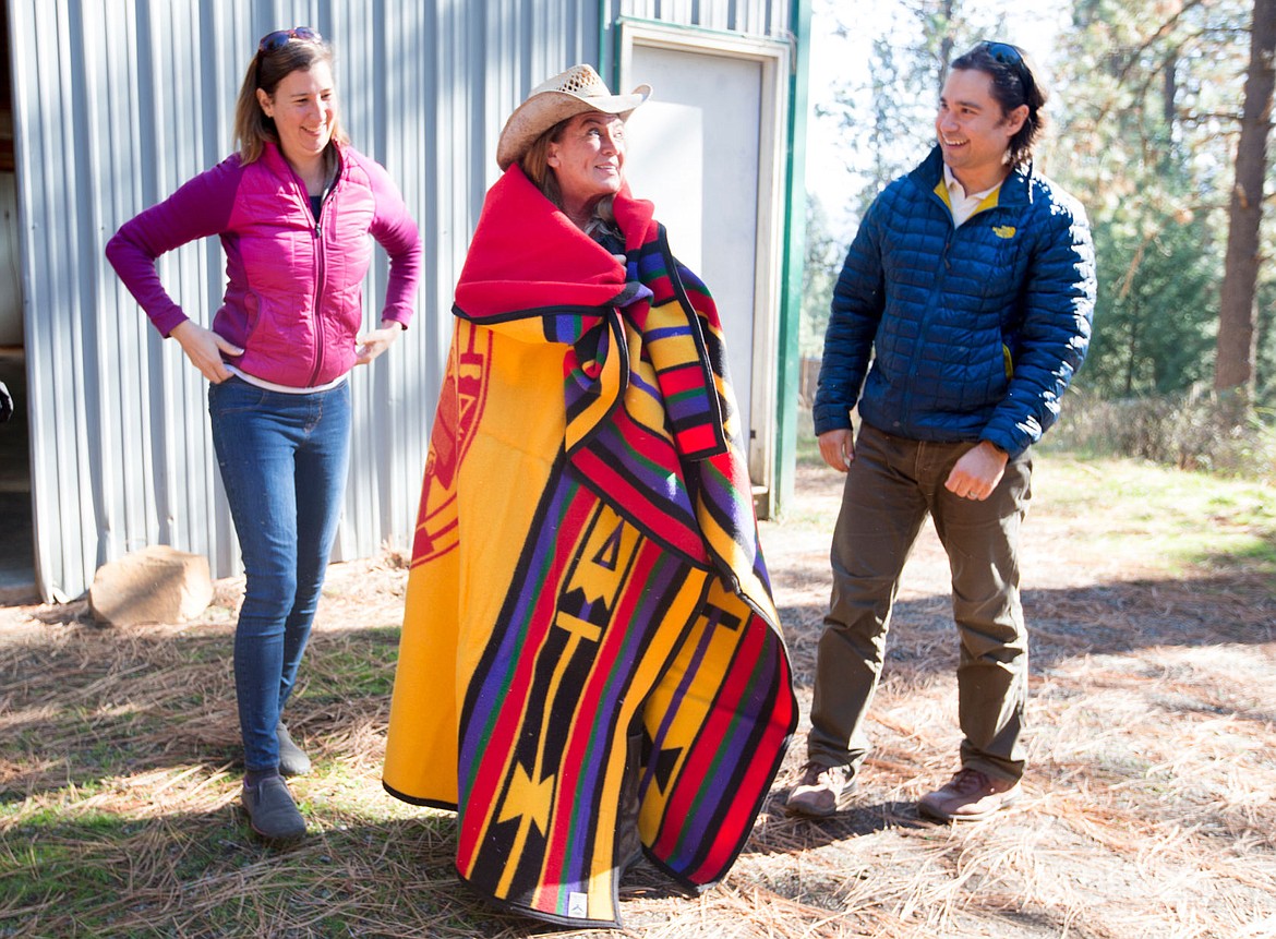 &lt;p&gt;Jane Veltkamp, owner and operator of Birds of Prey Northwest, smiles as she is wrapped in a Coeur d'Alene Tribe blanket as Jennifer Miller, permits chief for U.S. Fish and Wildlife, and Native American Liason for U.S. Fish and Wildlife Nathan Dexter look on Wednesday at Birds of Prey Northwest. The Tribe gifted the Pendleton blanket to Veltkamp for her contribution to the Tribe's new eagle aviary.&lt;/p&gt;