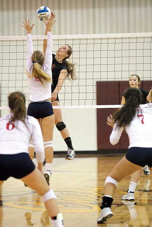 Moses Lake middle blocker Greta Hammer, black, sends a kill shot over the net against Eisenhower Thursday, Oct. 9.