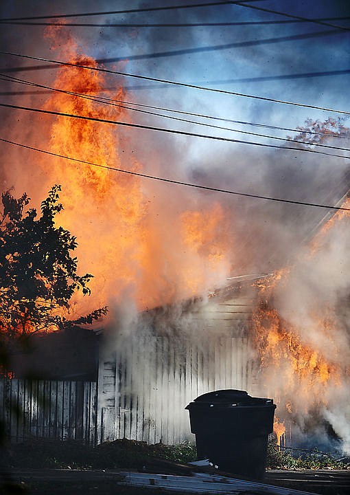 <p>Flames rise up at a structure fire in a detached garage along the alley between Second and Third Avenues West on Monday.</p>