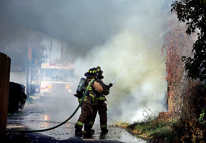 <p>Firefighters from the Evergreen Fire Department arrive to help battle a structure fire in a detached garage on Monday.</p>