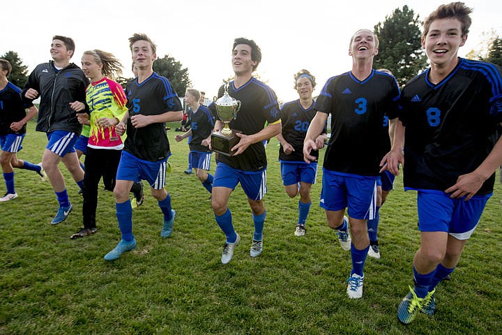 &lt;p&gt;Surrounded by teammates, Coeur d'Alene High School senior Austin Garitone carries the 5A Region 1 championship trophy after scoring the double-overtime ending goal to defeat Lake City on Wednesday at Lake City High School.&lt;/p&gt;