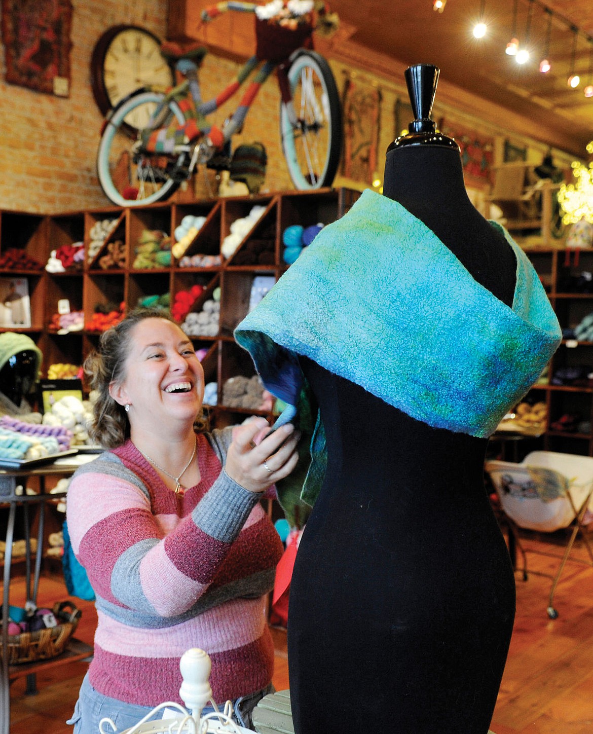 <p>Tracy Lee Sievers puts a scarf on a mannequin at Camas Creek Yarn. The shop offers a class on how to make the felted scarfs.</p>