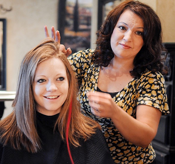 Jenna Olberding, a member of the Flathead sophomore volleyball team, gets a pink hair extension from Kay Bradley at Mirabelle in Kalispell on Saturday, October 2.