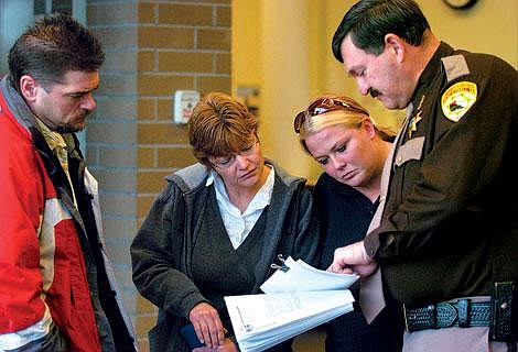 Flathead County Sheriff Mike Meehan shows photos made from video stills to Ginger Wilborn's mother, Cathy Putnam, of Columbia Falls, center, Wilborn's sister-in-law Shelley Putnam, and family friend Rodney Barnett on Wednesday morning at the Flathead County Justice Center in Kalispell. Wilborn was killed in an accident along with Roy Allen Moore and Montana Highway Patrol Trooper Evan Schneider on Aug. 26 in Bad Rock Canyon. Jennifer DeMonte/Daily Inter Lake