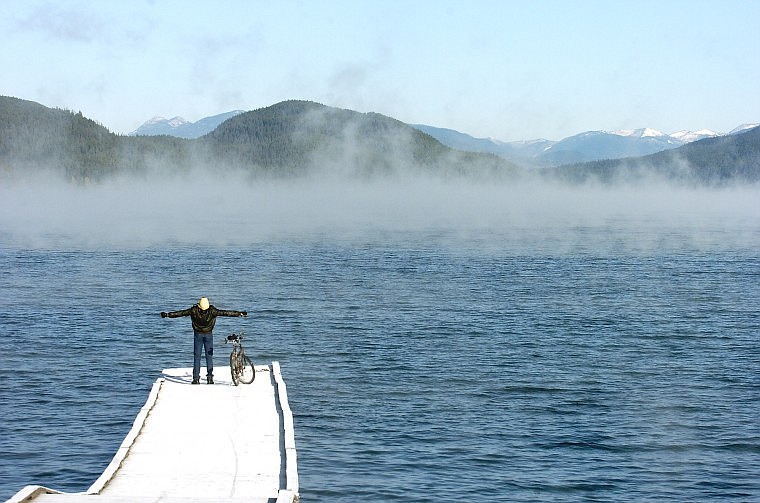 Bradley Tutsch stretches after a chilly bike ride Monday morning to Whitefish Lake, where steam rises off the water on the third straight day of record low temperatures. Monday&#146;s low of 6 degrees shattered the previous low of 20 for Oct. 12.