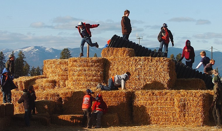 Members of Columbia Falls Cub Scout Troop 101 play on bales of hay before attempting to navigate the maze.