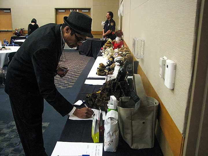 Joey Hernandez places a bid during the Grant County Animal Outreach Masquerade Ball Saturday night at Big Bend Community College. GCAO officials hope to raise upwards of $2,000 during the event to fund programs.