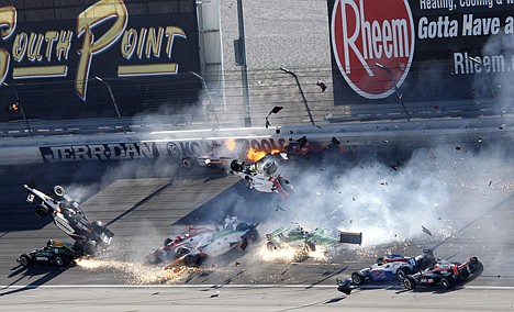 <p>Drivers, including Dan Wheldon (77, in air at left), crash during a wreck that involved 15 cars during the IndyCar Series race at Las Vegas Motor Speedway in Las Vegas on Sunday. Wheldon died following the crash.</p>