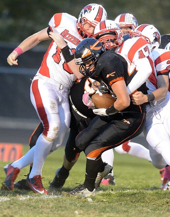 <p>Flathead senior running back Austin Root is stopped by a pack of Bozeman Hawks during Fridays Class AA football game at Legends Stadium.</p>