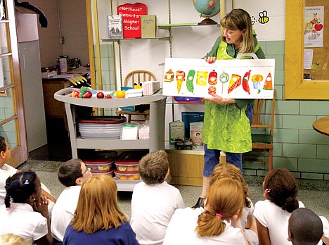 &lt;p&gt;In this Sept. 20, 2011 photo, Nancy Henderson, home economic coordinator for the fresh fruit and vegetables program, works with the students at Northeast Elementary Magnet, in Danville, Ill. The curriculum at the public school is focused on health and wellness, and families have to sign a contract agreeing to abide by that. School lunches are low-fat or no-fat, with fresh fruit or veggies every day, and no dessert. (AP Photo/Seth Perlman)&lt;/p&gt;