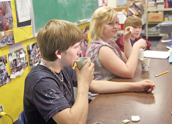 Troy eighth-graders Alex Yeadon, from left, Brenna Garrison and Ty Hight snack on turnip, pita and hot tea during their English class as part of their reading of the book, &#147;Three Cups of Tea.&#148;