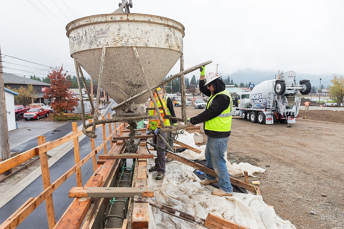 &lt;p&gt;Scott Lee, a carpenter/finisher for Ralph L. Wadsworth Construction, pours concrete into forms for a parapit wall while working on the Greensferry Road overpass.&lt;/p&gt;