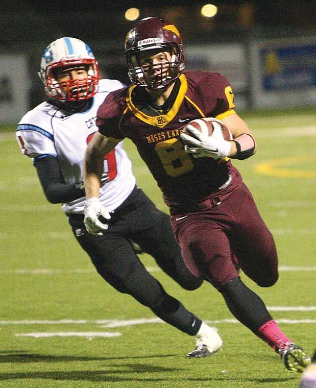 Moses Lake running back Nathan Ball, 6, runs away from Eastmont defensive back Abi Espinoza, 9.