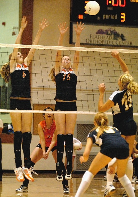 Flathead High School middle blocker Kwyn Johnson (left) and outside hitter Hannah Sackett jump to block a shot by Missoula Big Sky outside hitter Katie Anderson during the third game at Flathead Tuesday night.