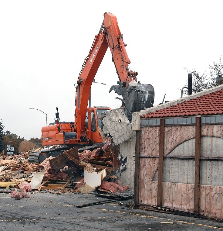 A machine operated by Keith Johnson of R. Smith Excavating of Lakeside cuts through a wall of the Sawbuck Saloon and Casino building on Wednesday morning. The building is being razed to make room for a Montana Club restaurant and casino.