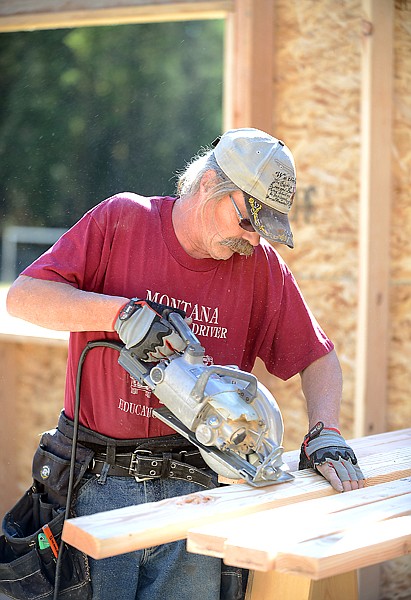 <p>Flathead Valley Community College's Building Trades student Rick Parsons saws boards for the addition to Olney-Bissell School.</p>