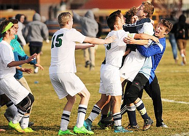 <p>The Wolfpack rush to congratulate Ben Wright after he scored the winning goal in the shootout to beat Helena Capital and advance to the state tournament. (Aaric Bryan/Daily Inter Lake)</p>