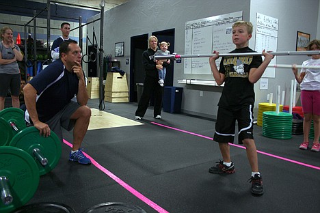 &lt;p&gt;Eight-year-old Dylon Moore of Coeur d&Otilde;Alene lifts a 15-pound bar at a weightlifting competition at Lotus CrossFit on Saturday, while his father Greg keeps watch to the side. Dylon&Otilde;s mother Jennifer Brumley also watches from behind.&lt;/p&gt;