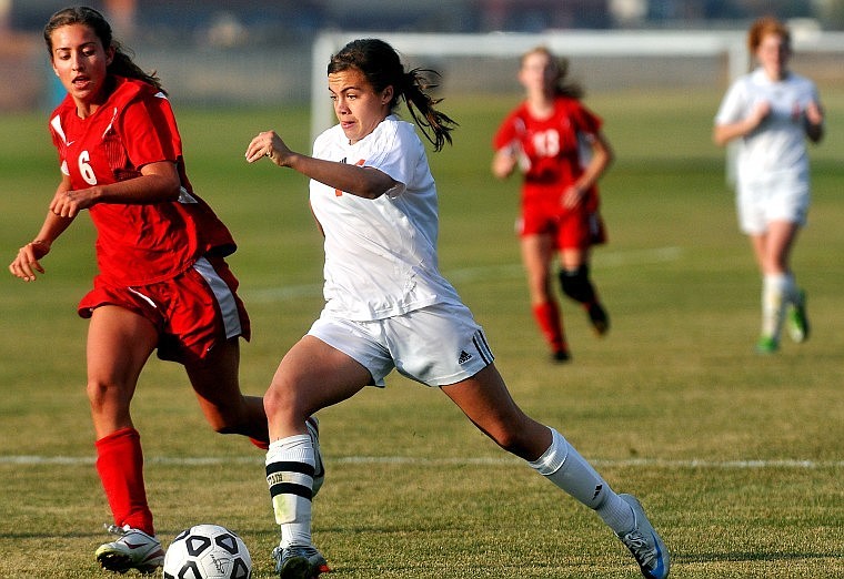 Flathead's Chelsea Shuman carries the ball up the field past Missoula Hellgate's Ellie Shields (6) in the first half of Friday afternoon's game in Kalispell.