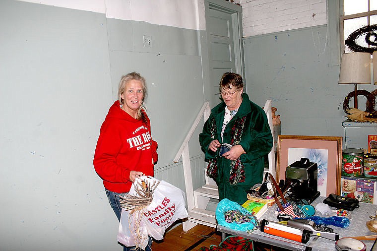 &lt;p&gt;Karina Woodford looked over items being sold by Jan Christensen during the community yard sale on Saturday.&lt;/p&gt;