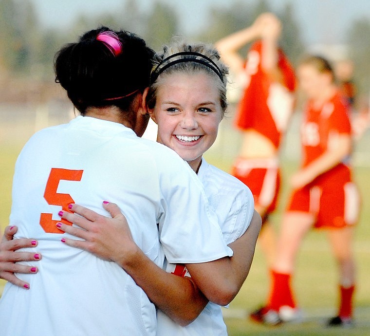 Flathead's Jaclyn Rauthe gets a hug from teammate Malia Ozegovich (5) at the end of the game, celebrating the team's advancing to the Class AA state tournament next weekend. Rauthe scored the team's second goal.