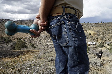 &lt;p&gt;Paul Dotsie holds a rubber bone as he and his dog, Buster, search an area near Bishop, Calif., on Sept. 20. As a cadaver dog Dostie said that Buster has helped find the remains of about 200 people. As a reward after indicating an &quot;alert&quot;,Dostie tosses Buster the toy.&lt;/p&gt;