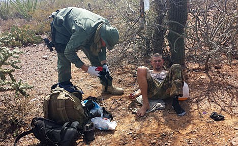 &lt;p&gt;In this June 25, 2014 photo, an unidentified U.S. Border Patrol agent, left, helps an immigrant, including setting up intravenous fluid replacement for dehydration, near Sells, Ariz. The number of migrants who died or needed rescue while crossing the desert from Mexico into Arizona has dropped significantly this year.&lt;/p&gt;