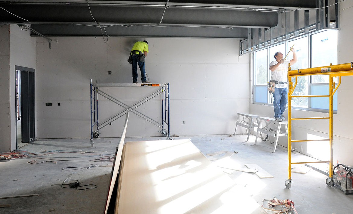 <p>Workers install sheetrock in a new classroom at Bigfork High School on Tuesday.</p>