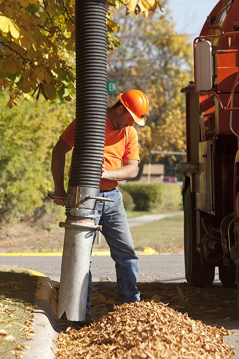 <p>Kalispell city worker Mike Nelson cleans up leaves off the side
of East Washington Street Tuesday afternoon.</p>