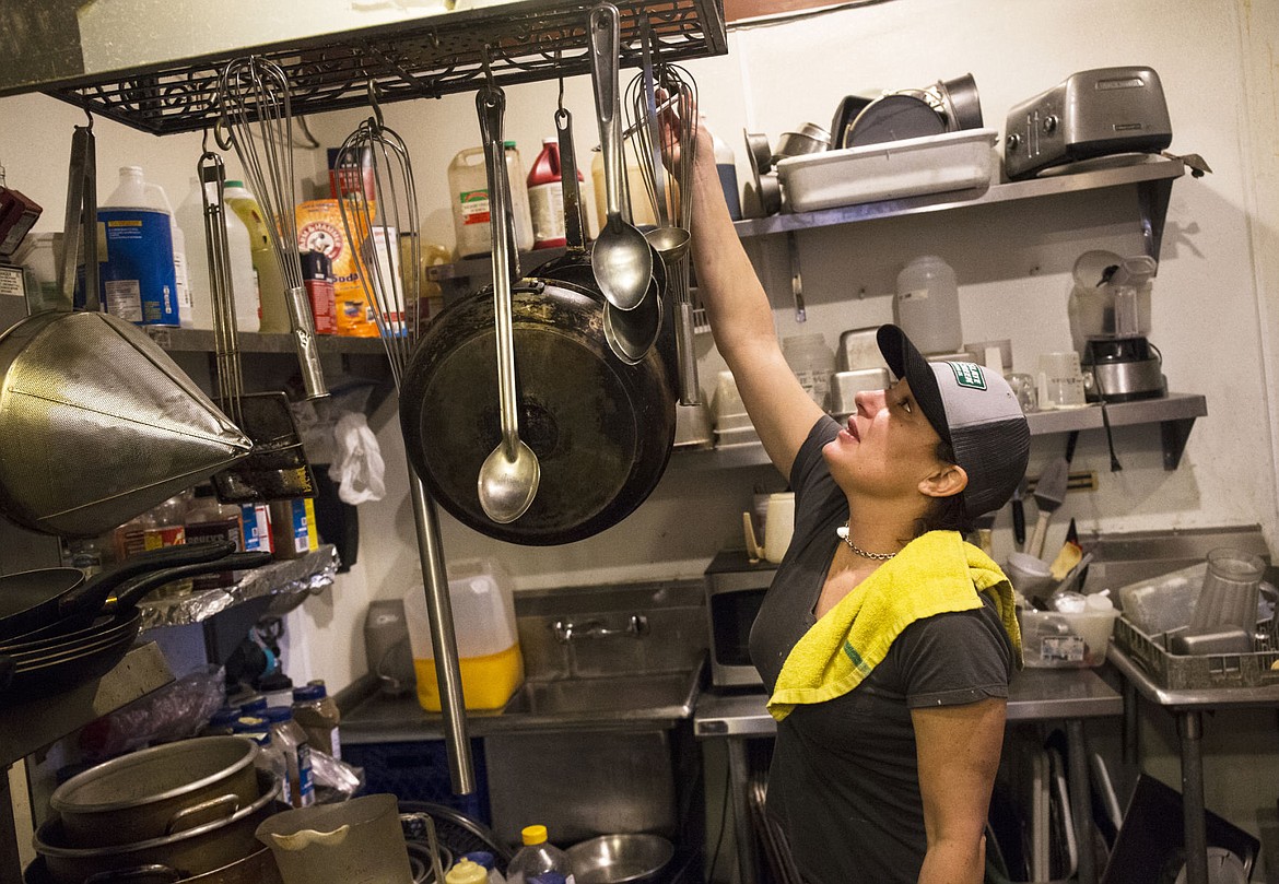 &lt;p&gt;LOREN BENOIT/Press Amber Clark, kitchen manager and head cook at Kelly's Irish Pub and Grill, places a tong on the utensils rack while working Friday morning. Clark has had numerous interactions with an unknown prescence, including an instance where a tong fell off the utensils rack.&lt;/p&gt;