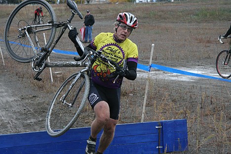 &lt;p&gt;Brad Scott, competing in the over-50 category, carries his bike over an obstacle in an Inland Northwest Cyclocross Series event Sunday at Riverstone Park. More than 100 cyclists competed on a wet and muddy course.&lt;/p&gt;