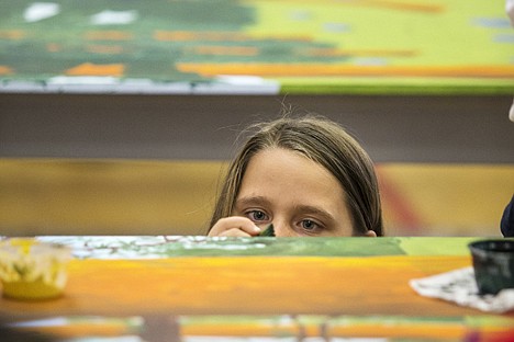 &lt;p&gt;Deanna Laird, 10, takes a bugs-eye view in order to paint greenery on the edge of a section of a large mural depicting Tubbs Hill at Sorensen Magnet School of the Arts and Sciences Thursday. The 6 by 40 foot painting, designed by local artist Jessica L. Bryant, will be displayed outside of the gym upon completion.&lt;/p&gt;