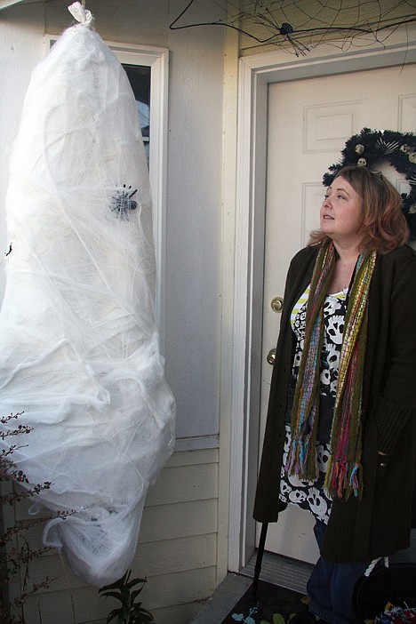 &lt;p&gt;Becky Albrecht glances over a Halloween decoration, the victim of a giant spider, she made for her porch.&lt;/p&gt;