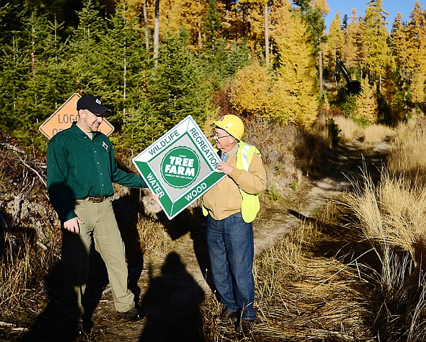 <p>Mark Boardman of the F. H. Stoltze Land and Lumber Co., who is currently the Montana Tree Farm Chairman presents a Tree Farm sign to John Chase as part of the Montana Forest Products Industry Week. (Brenda Ahearn/Daily Inter Lake)</p>