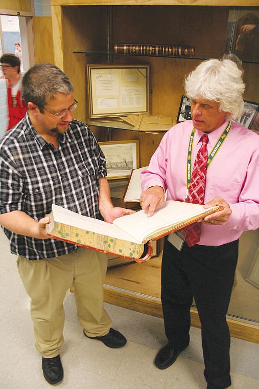 &lt;p&gt;Sean O&#146;Donnell, head of the Flathead High School social science department and history teacher Pat Reilly look through a book of handwritten school board minutes in front of a display case Reilly constructed to hold historical documents, photos or memorabilia relating to Flathead High School and the district. The project, called History in the Hallways, was organized by O&#146;Donnell to get students connected to their school&#146;s past. Artifacts dating back to 1899 are on display at the school.&lt;/p&gt;