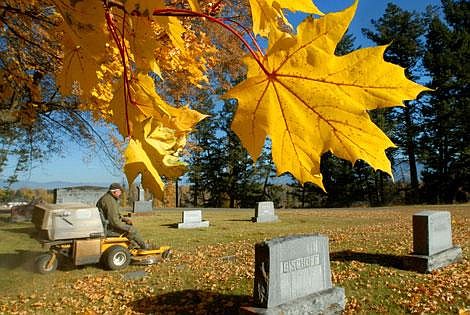 John Johnson, a maintenance worker with the Conrad Memorial Cemetery in Kalispell, clears fallen leaves from the grounds of the 106-year-old cemetery. The rows of big maples and other non-native deciduous trees were planted over 100 years ago when the cemetery was being designed. The cemetery is named after Charles E. Conrad, a founder of Kalispell, who was the first person buried there.(Photo by Karen Nichols/Daily Inter Lake)